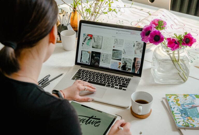 woman-in-a-creative-workspace-using-a-laptop-and-tablet-for-calligraphy.-artistic-and-tech-driven-environment.