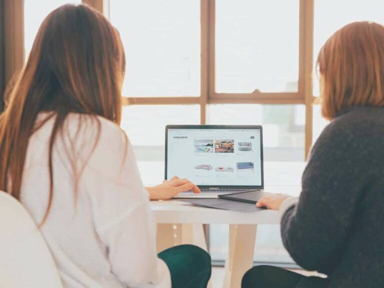 2 women showing mentoring, looking at laptop screen setting up an online business